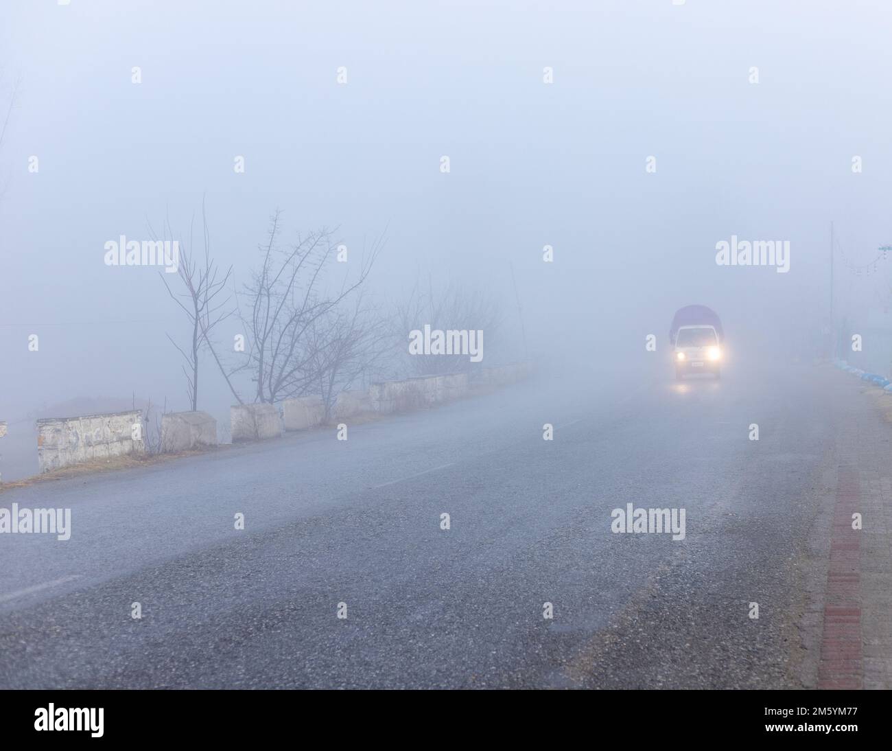 Low traffic on a road in a foggy weather with low visibility Stock Photo