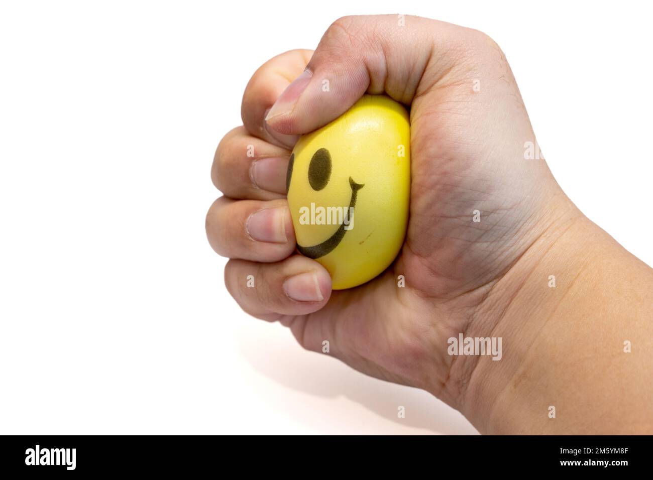 Hand squeeze yellow stress ball, isolated on white background, anger management, positive thinking concepts Stock Photo