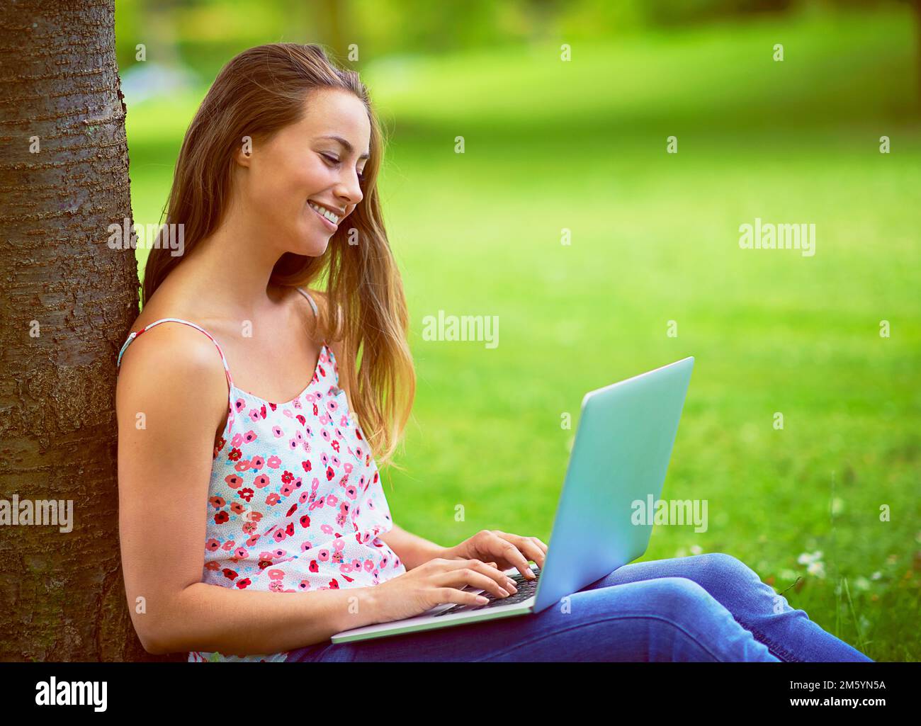 Doing some blogging at the park. a young woman using her laptop at the park. Stock Photo