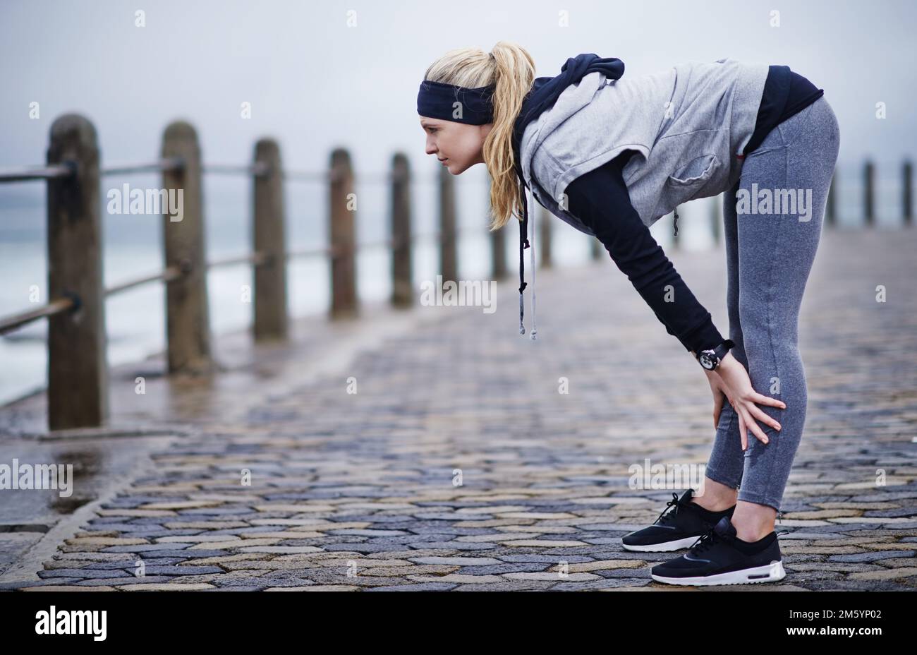 Taking a quick breather. a young woman catching her breath after a run