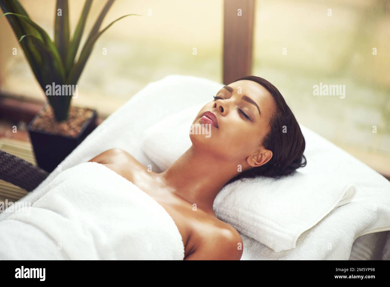 Relaxation begins now. an attractive young woman relaxing on a massage table at a beauty spa. Stock Photo