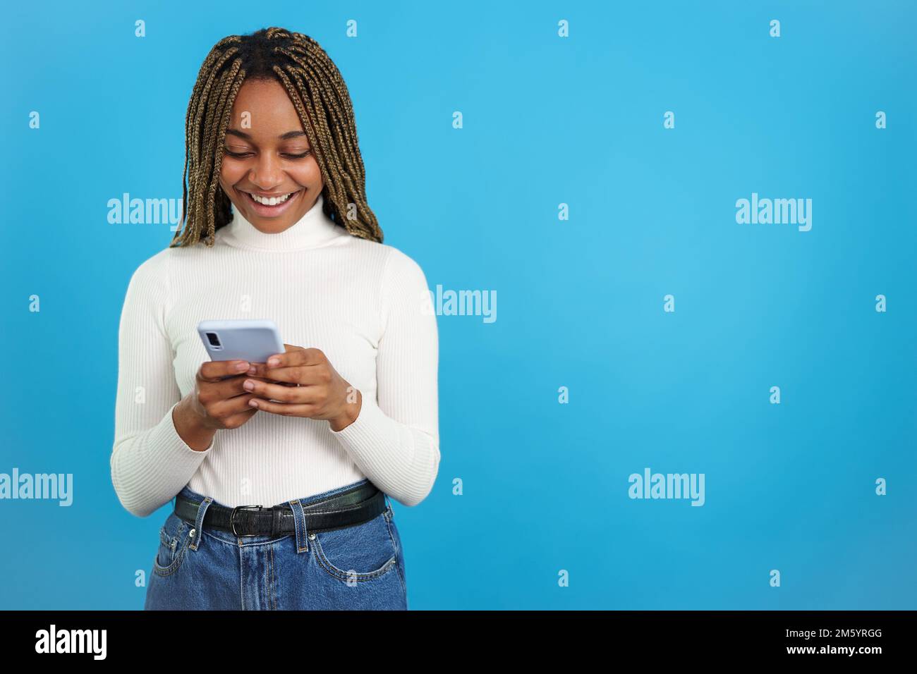 Happy cool african woman using the mobile Stock Photo