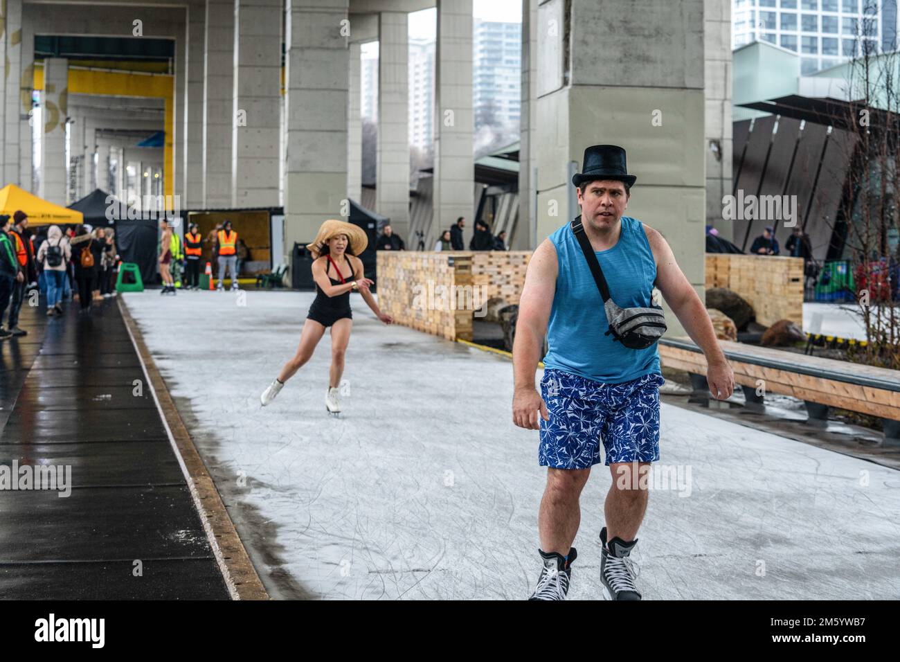 Toronto, Canada. 31st Dec, 2022. Ice skaters wearing a top and straw hat brave the cold on a