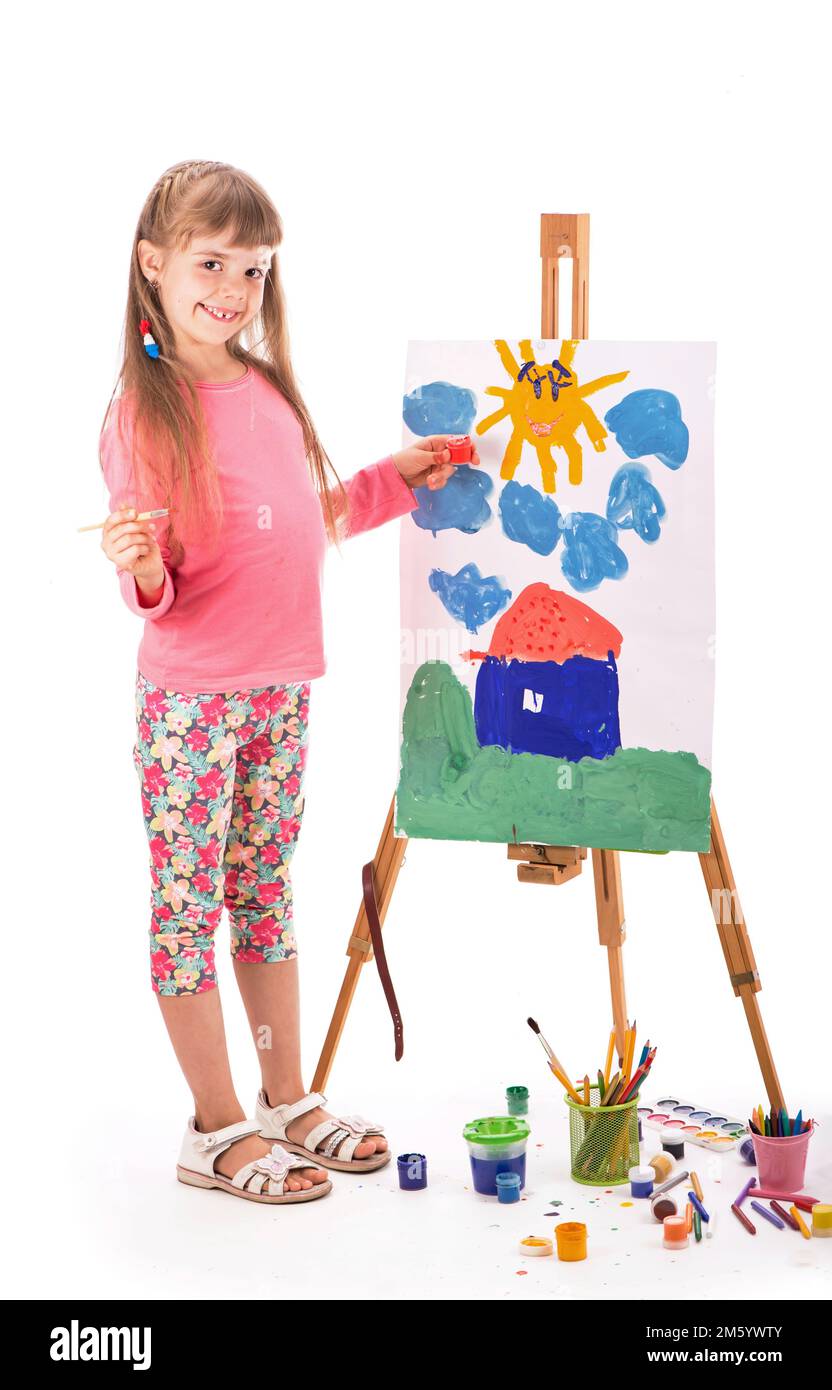 The child draws a house. Children's painting. Little girl draws the sun. The schoolboy does his homework in art. Arts and crafts for children. Paint Stock Photo