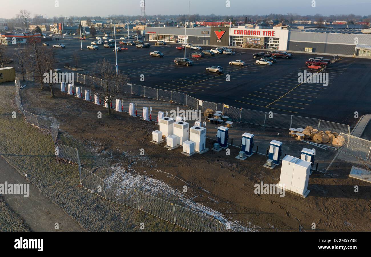 Newly installed electric vehicle charging stations and Tesla Superchargers are seen while still closed for construction on a sunny morning in Canada. Stock Photo