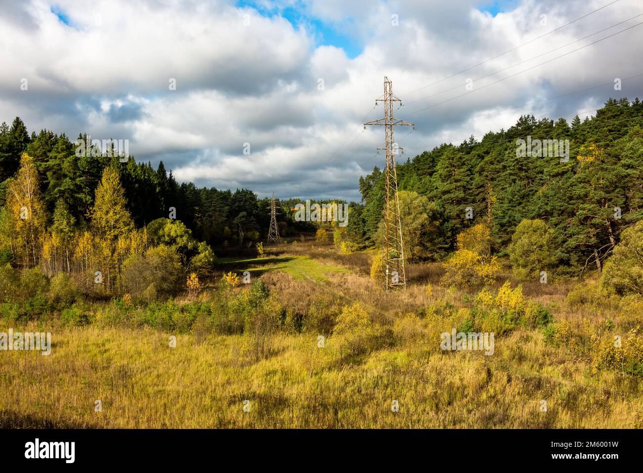 Highvoltage power line passing through a picturesque valley surrounded