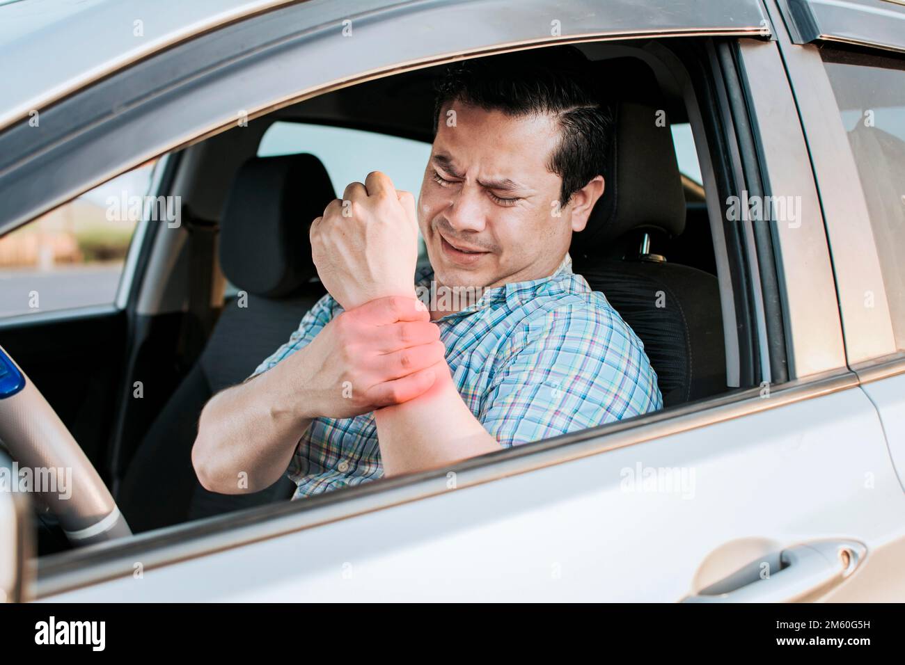 Driver suffering from wrist pain. Sore driver man touching his wrist