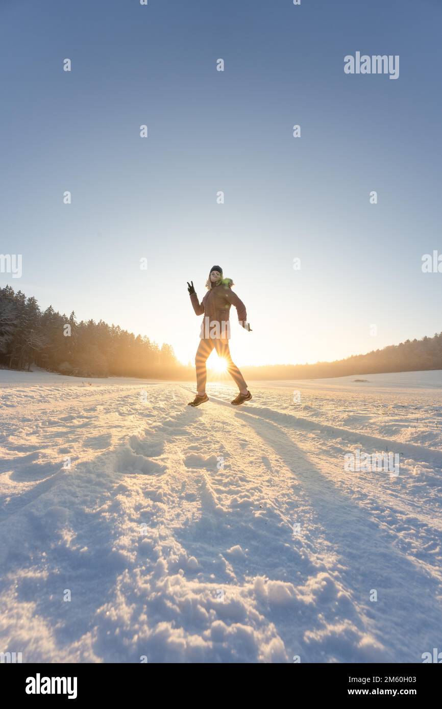 Dancing woman in the snow at sunset, Gechingen, Black Forest, Germany Stock Photo
