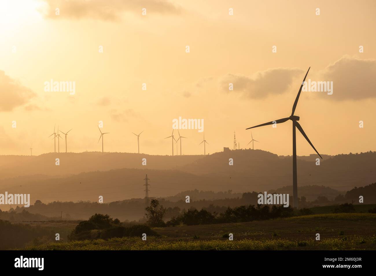 The silhouettes of wind turbines at sunset with the orange sky in the ...