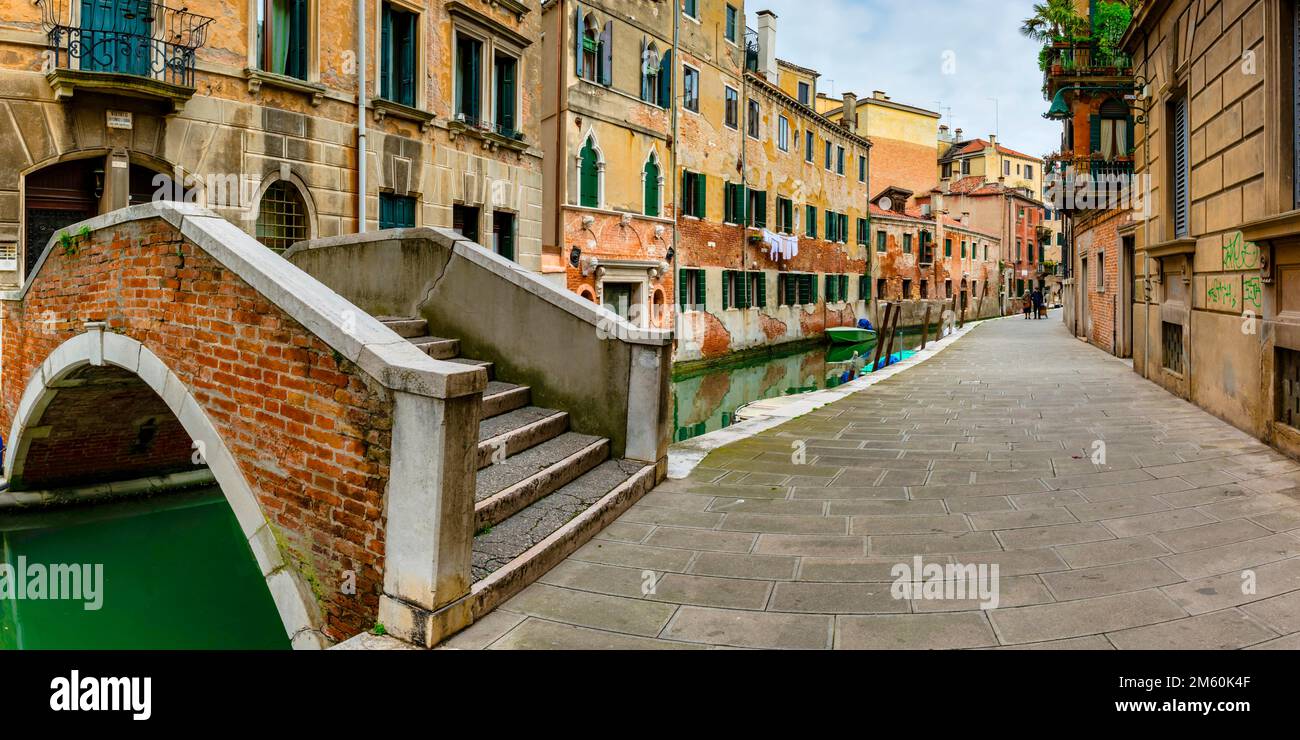 Arched bridge over the old town canal, alley with old couple, Venice ...