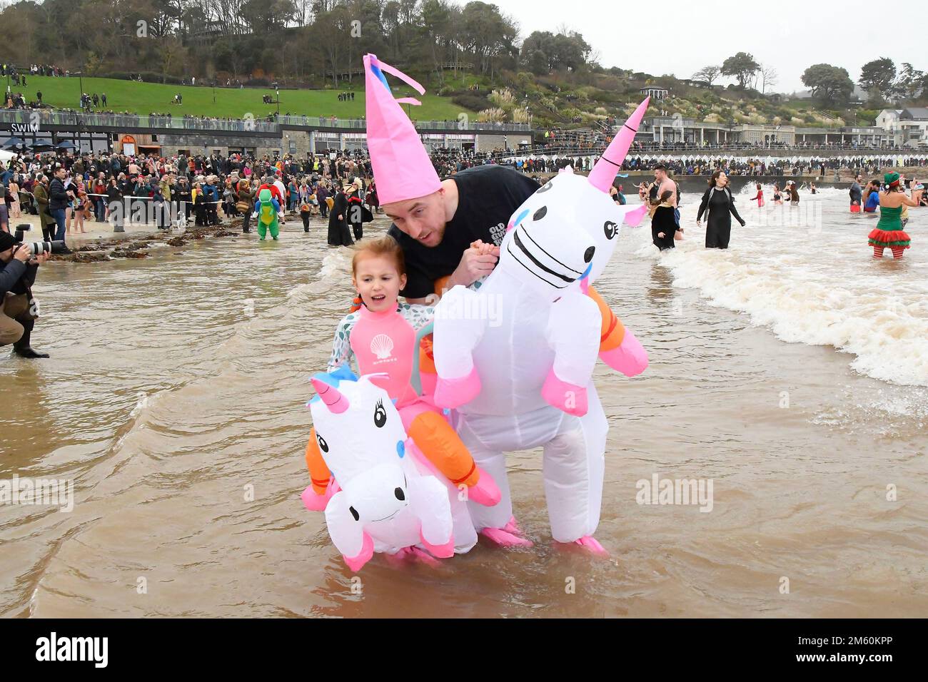 Lyme Regis, Dorset, UK.  1st January 2023.  Hundreds of New Years Day revellers in fancy dress, watched by huge crowds, take part in the annual Lyme Lunge charity swim at Lyme Regis in Dorset in aid of Mencap and the National Heart Foundation on an overcast damp day.  Picture Credit: Graham Hunt/Alamy Live News Stock Photo