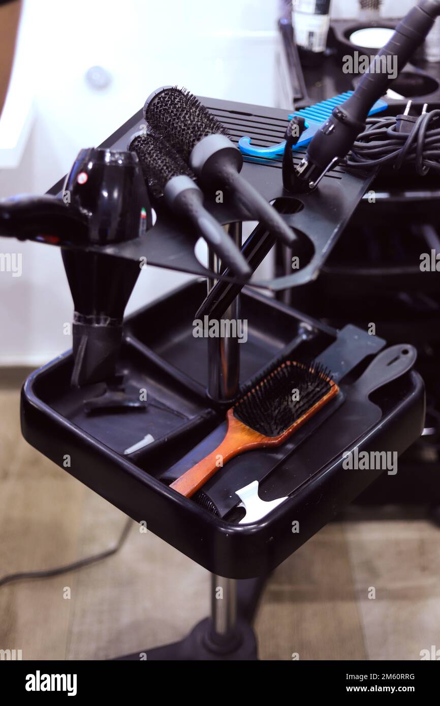 hairdressing table with tongs, hair dryer and brushes Stock Photo Alamy