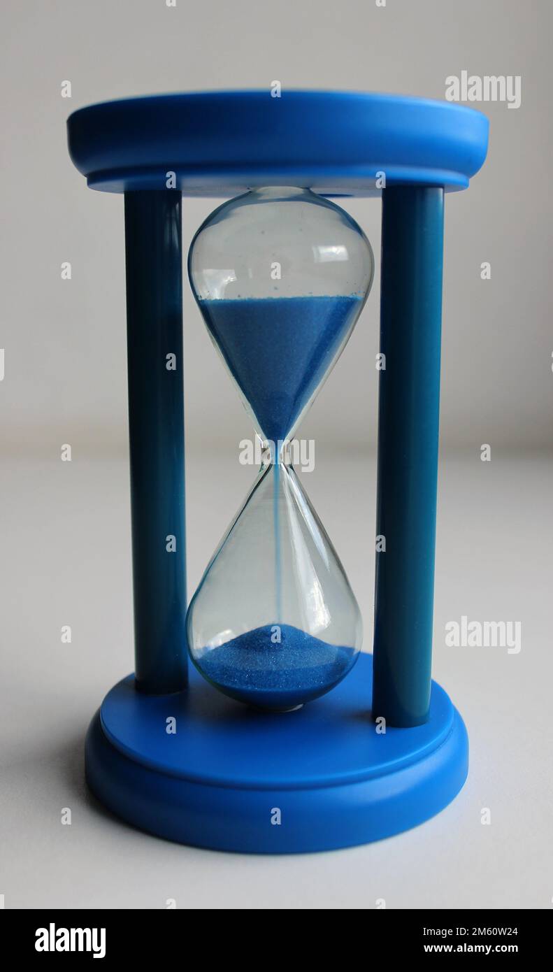 Hourglass with falling sand counting down the time top angle view Stock Photo