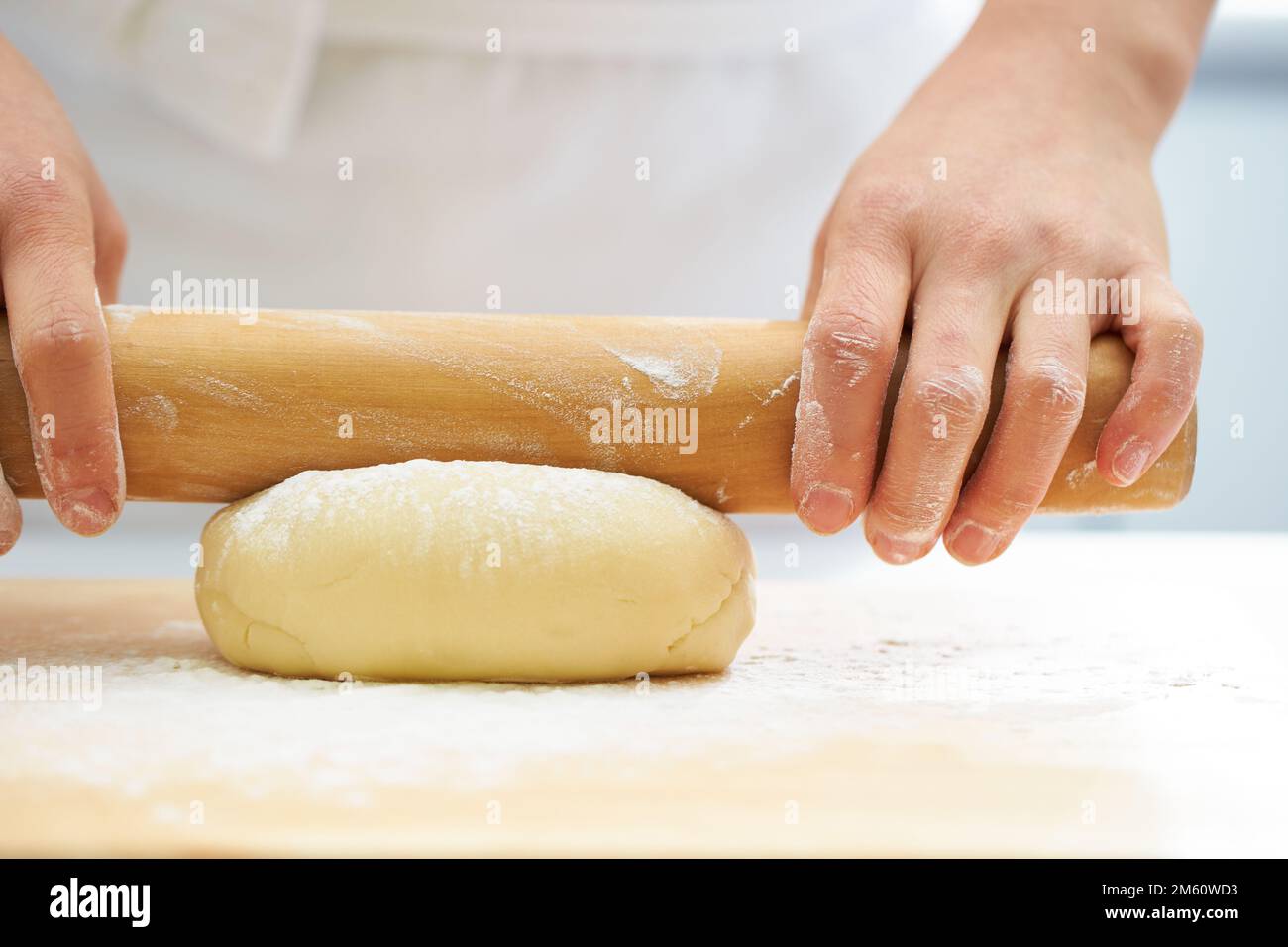 View of Rolling the dough with a rolling pin, bread making process Stock Photo ...