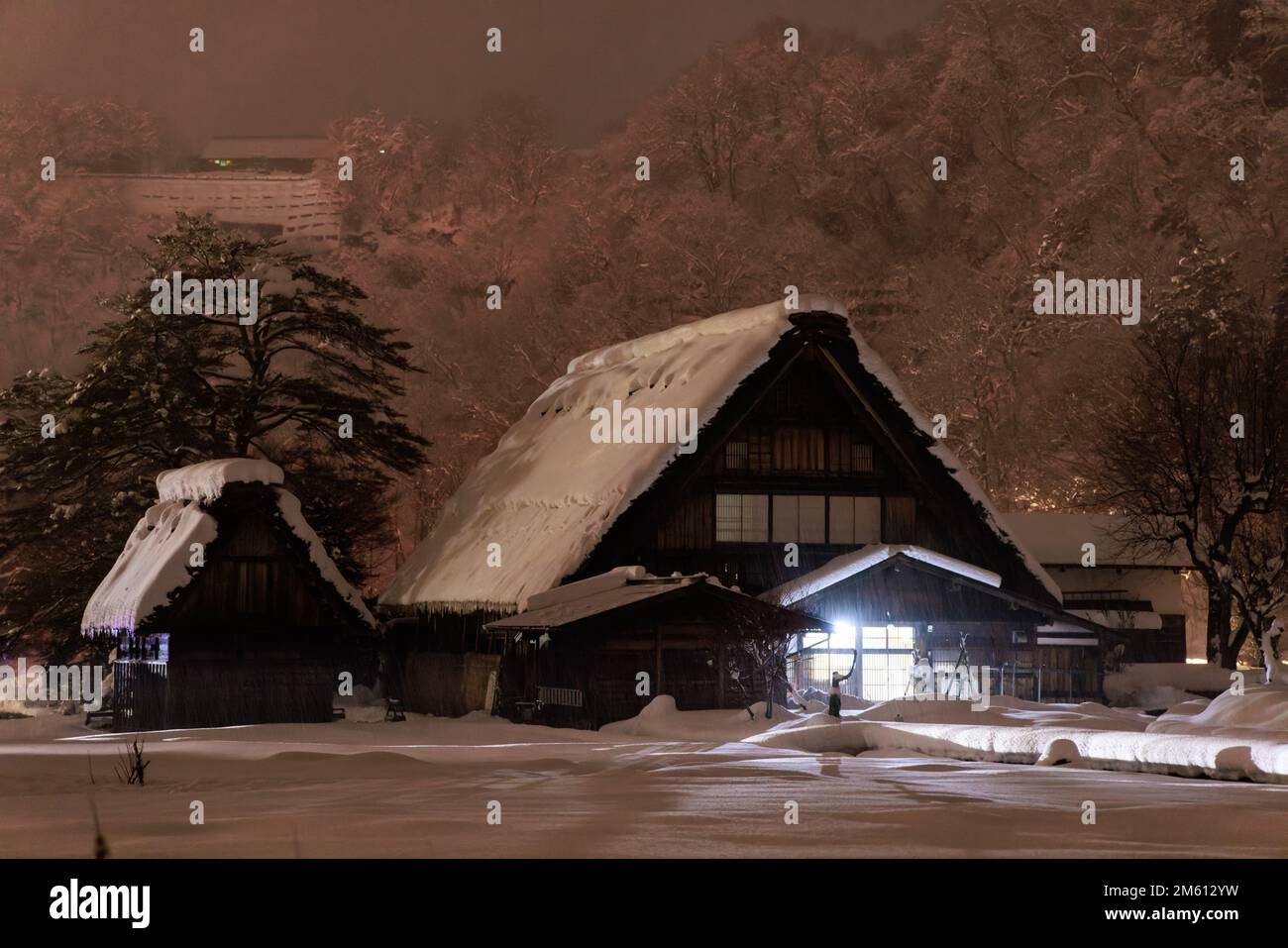 Pink misty glow over traditional Japanese farmhouse in village at night Stock Photo