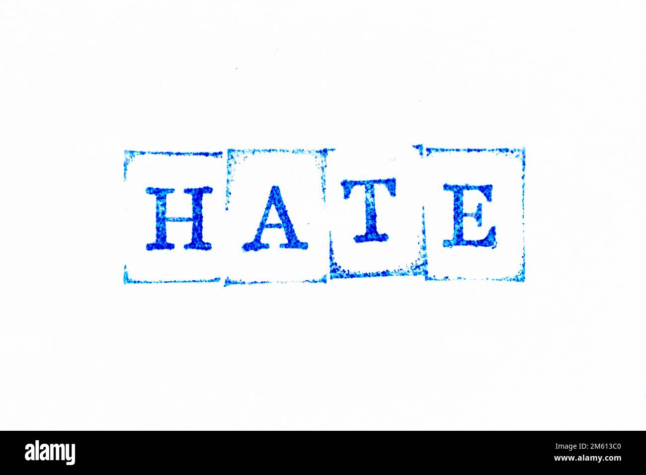Blue color ink rubber stamp in word hate on white paper background