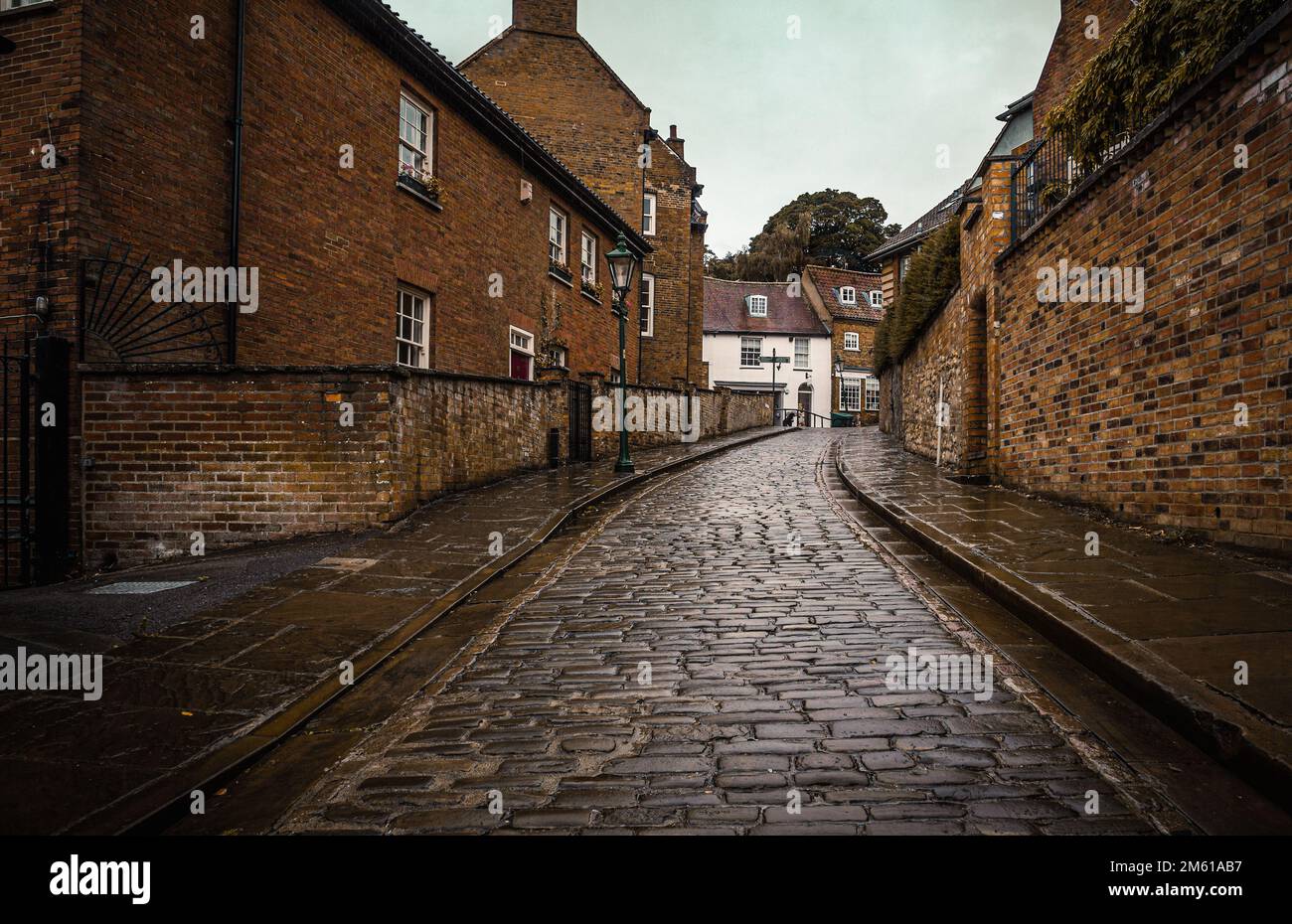 A long cobbled street lined by houses in Lincoln, England, UK Stock