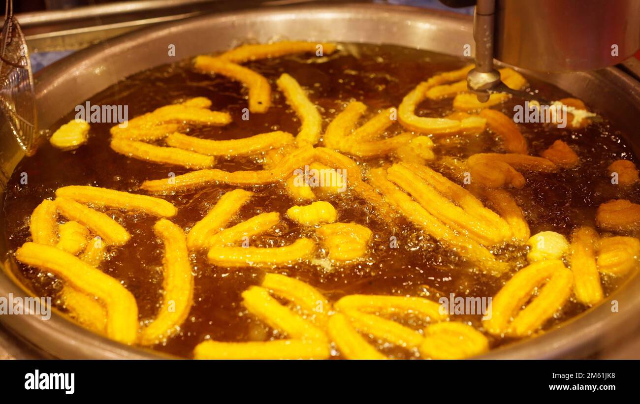 Frying Mexican churros in hot oil Stock Photo Alamy