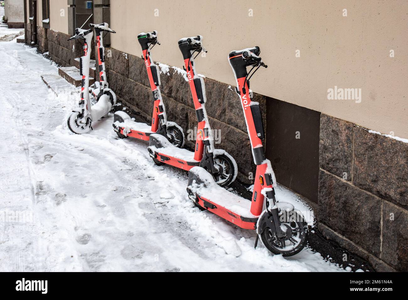 Voi e-scooters in snow in Helsinki, Finland Stock Photo