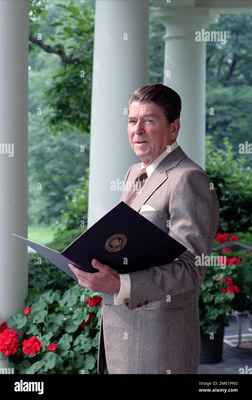 6/4/1985 President Reagan reading on the Colonnade President Ronald Reagan reading on the Colonnade, White House, 1985 Stock Photo