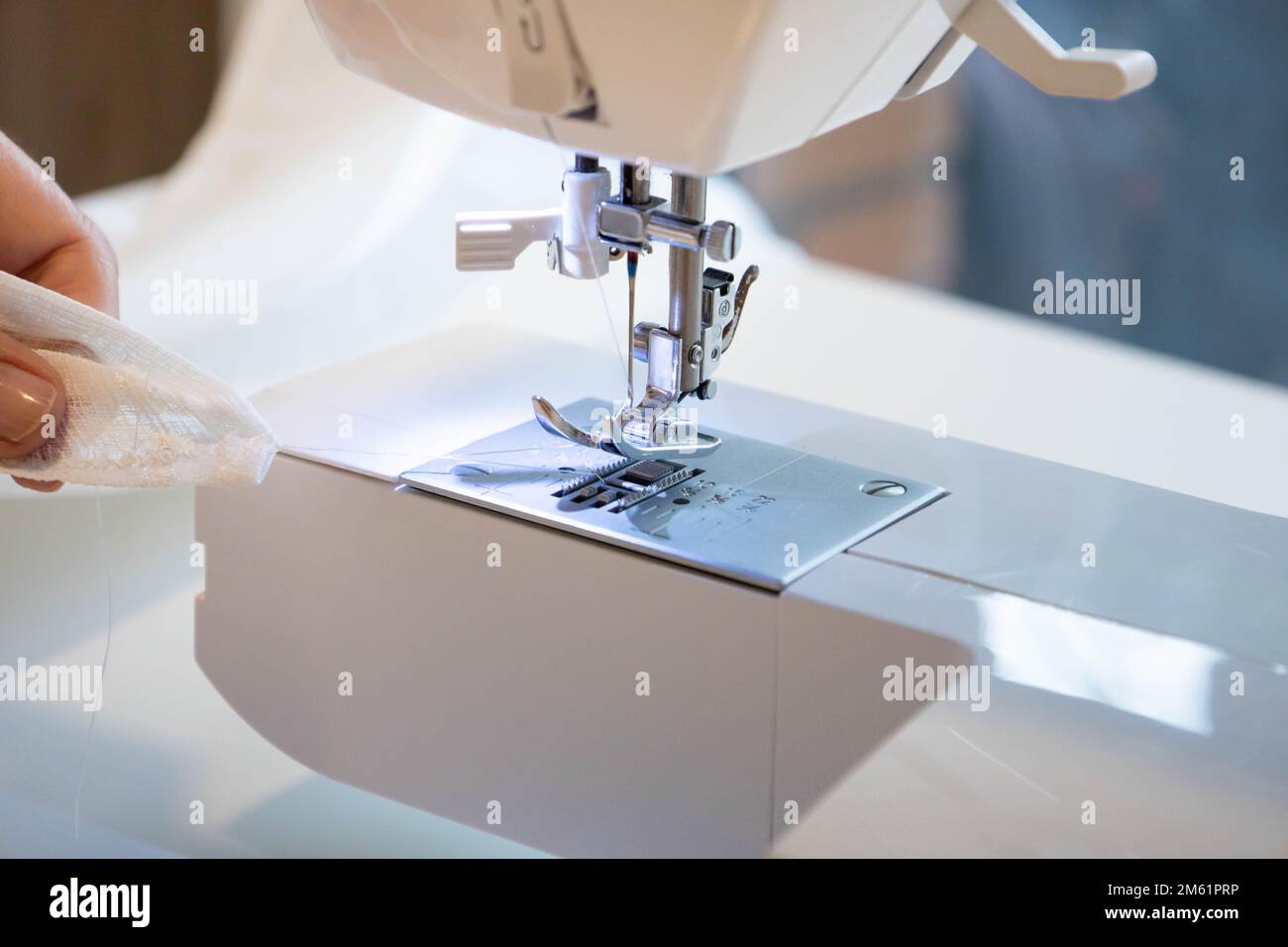 Close up top side view of cropped female hands sewing fabric in ...