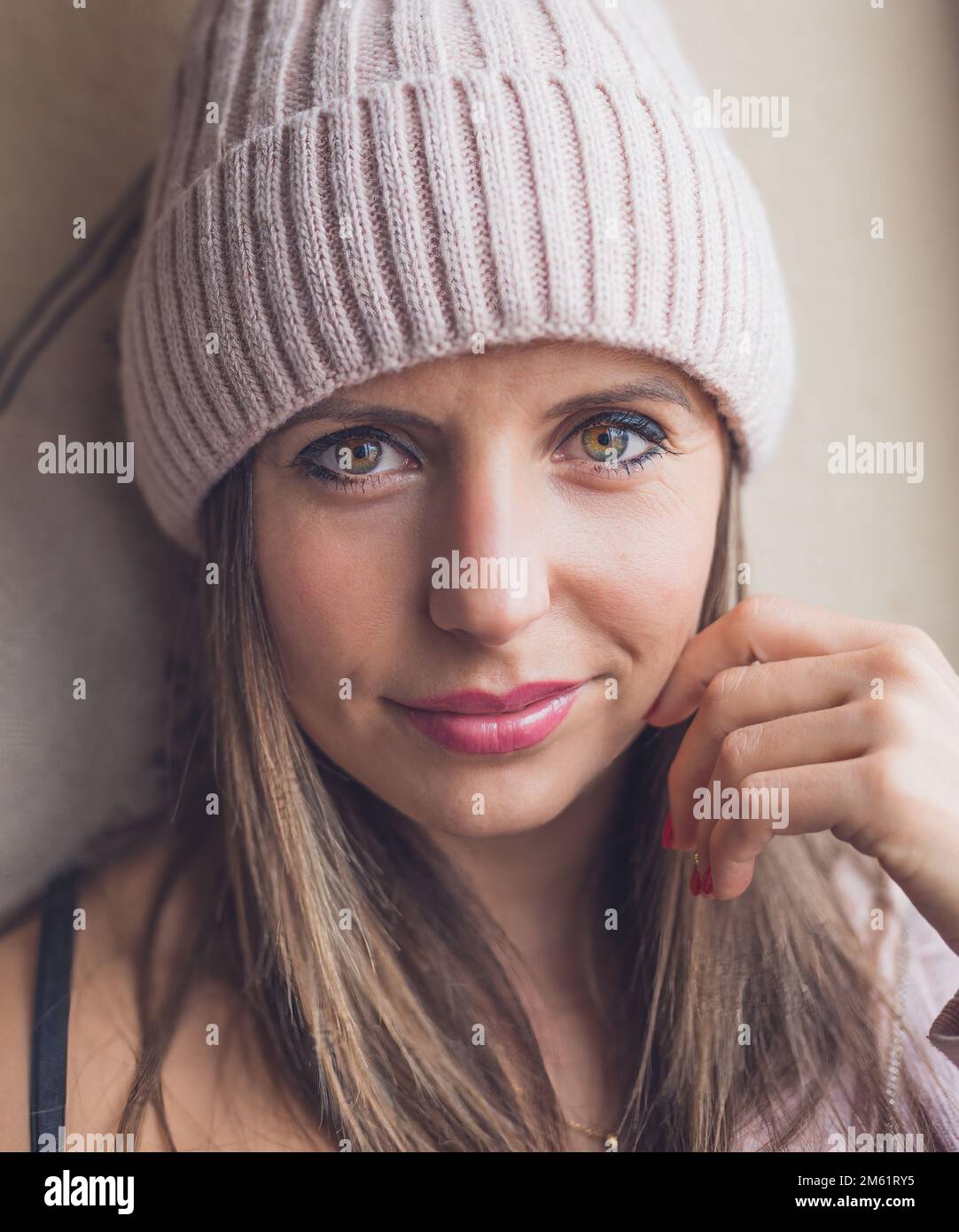 portrait of a Caucasian woman wearing a woolen cap and smiling. Looking at camera. natural light. Stock Photo