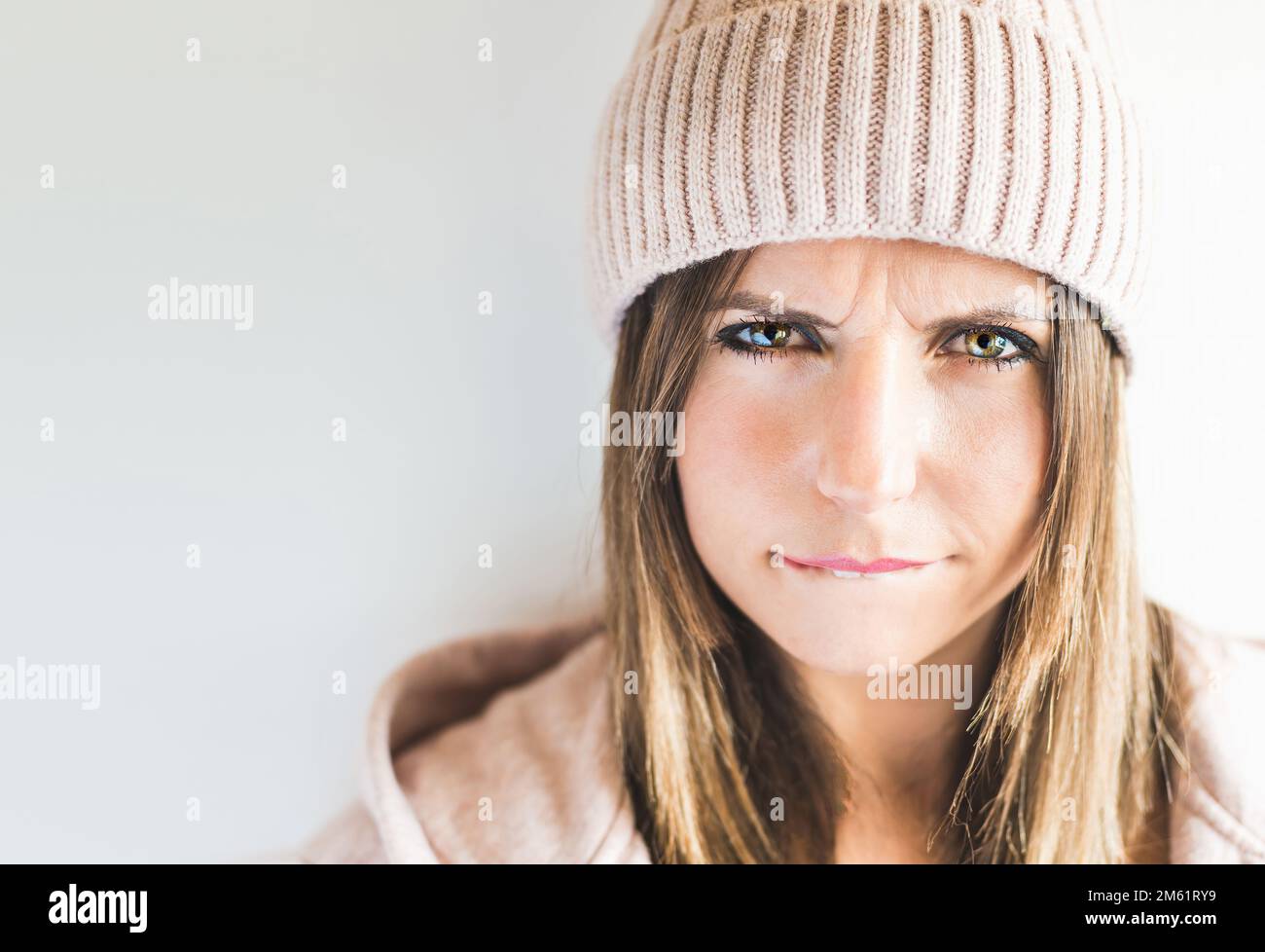Close-up of a Caucasian woman wearing a cap, looking with an angry expression. Angry concept Stock Photo