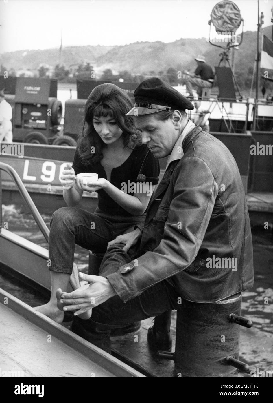 JULIETTE GRECO and O.W. FISCHER on set location candid on boat on river Rhine during filming of WHIRLPOOL 1959 director LEWIS ALLEN novel / screenplay The Lorelei by Lawrence P. Bachmann music Ron Goodwin costume design Julie Harris The Rank Organisation Stock Photo