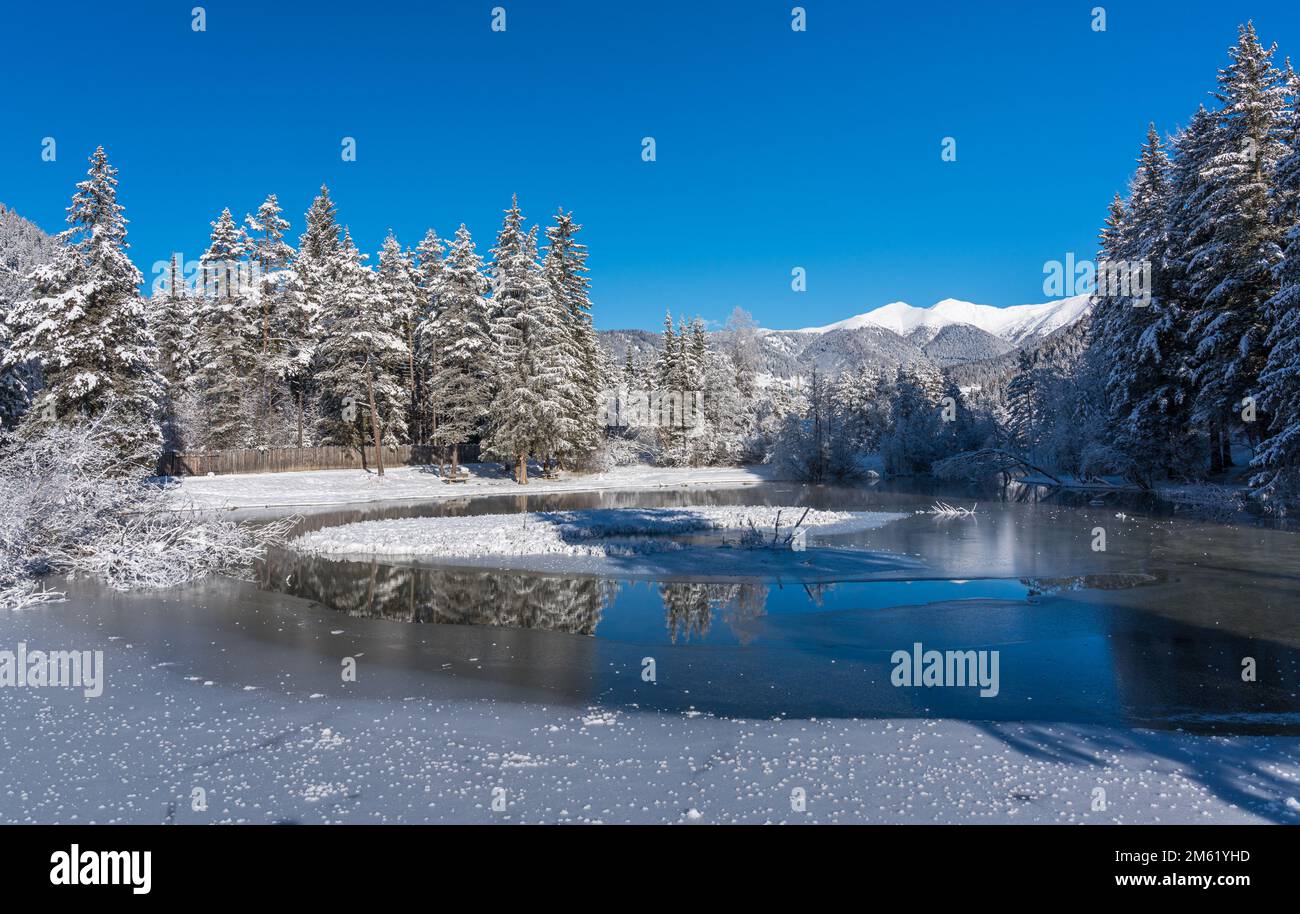 A sunny winter morning ata snowy and iced Lake Dobbiaco, Province of Bolzano, Trentino Alto Adige, Italy. Stock Photo