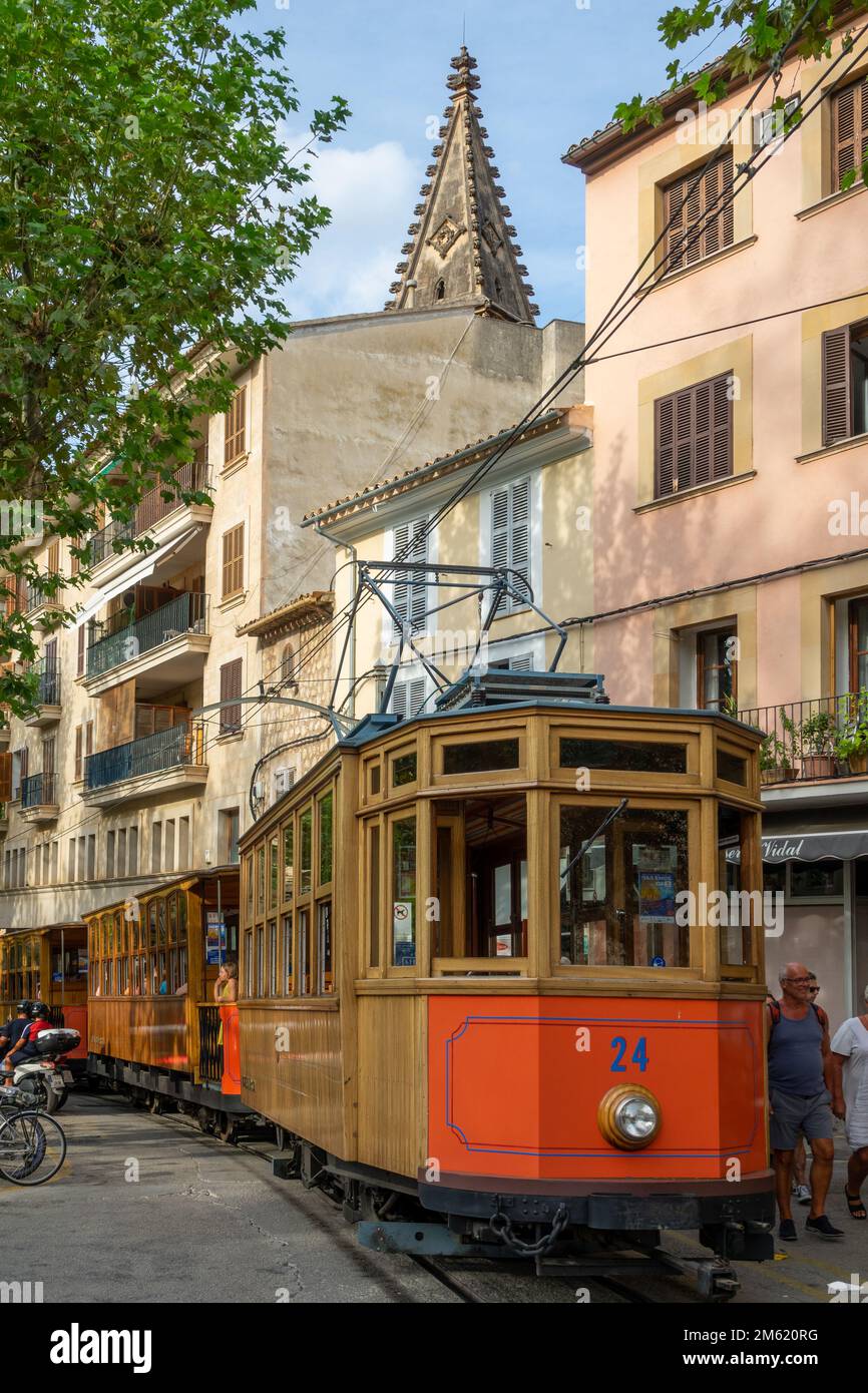 Soller, Spain; August-27, 2022: Popular Soller train in Mallorca (Spain), passing through the town center full of people, restaurants and monuments Stock Photo