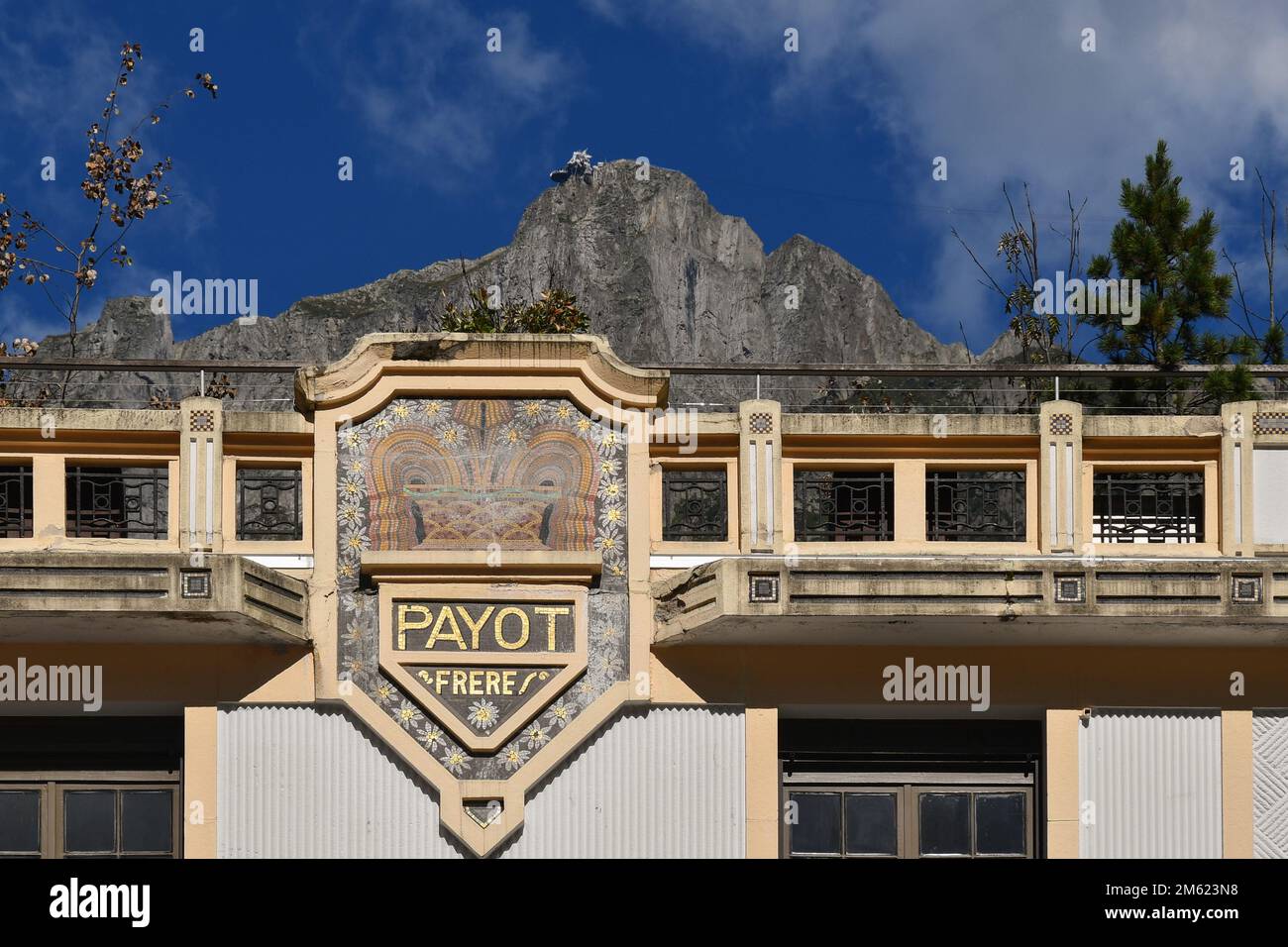 Top of the Art Deco building of the Payot Bank in the centre of Chamonix with the Brevent cable car station on the peak in the background, France Stock Photo