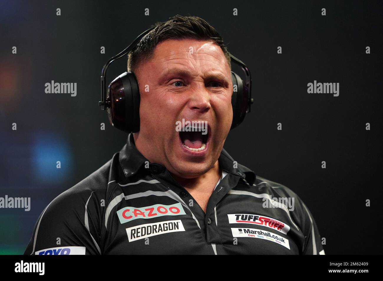 Gerwyn Price can be seen wearing ear defenders during his match against