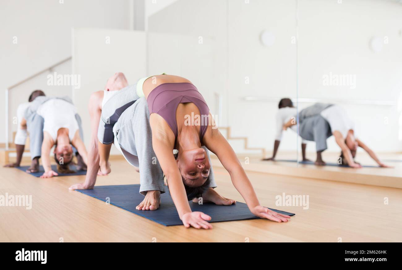 Couples practicing yoga with partner at studio Stock Photo
