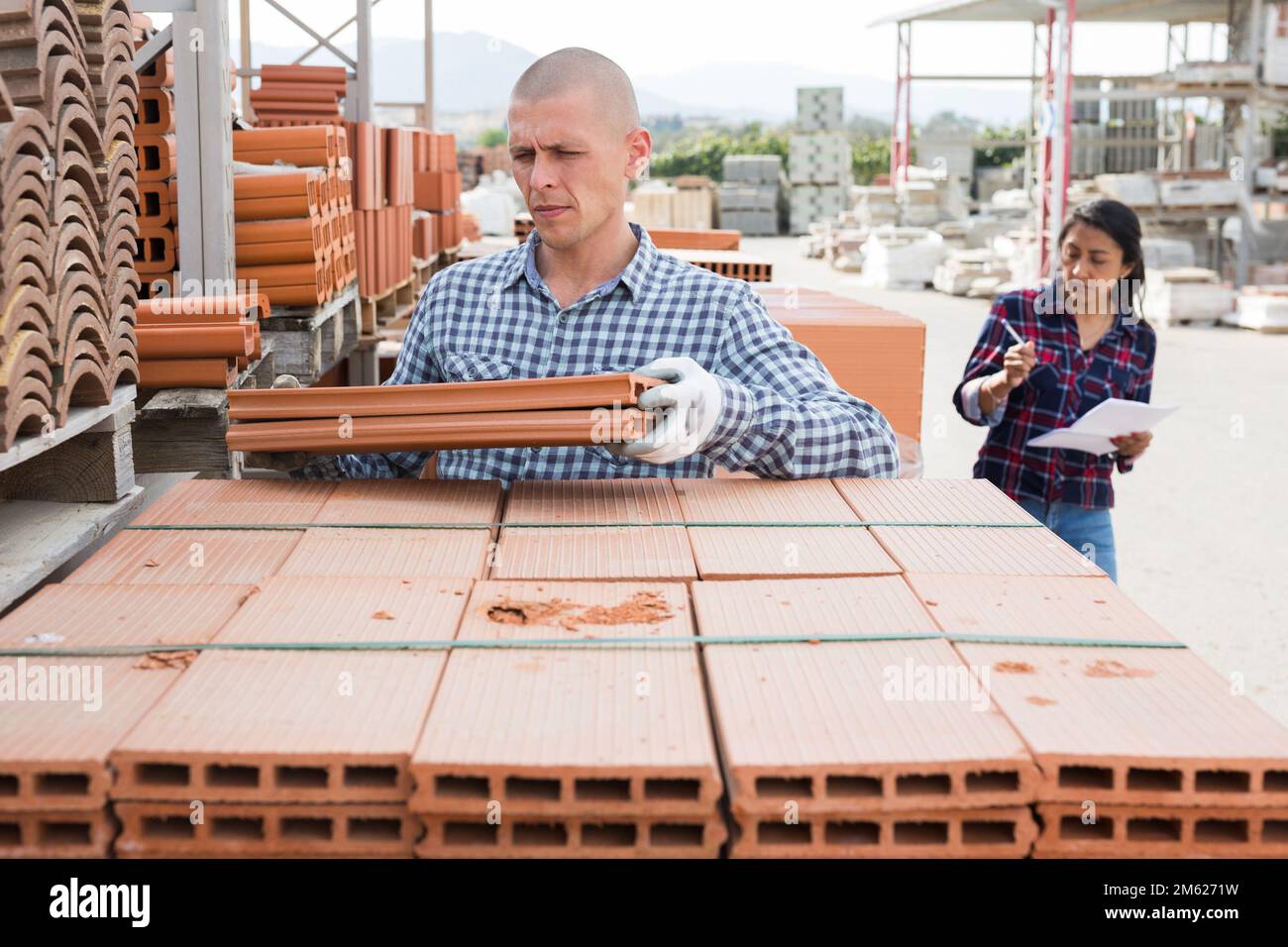 Worker stacking bricks in warehouse of materials Stock Photo Alamy