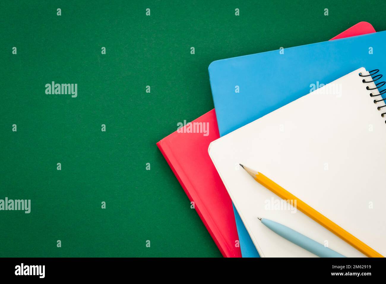 Notebooks on green background, school concept, flat lay. Stock Photo
