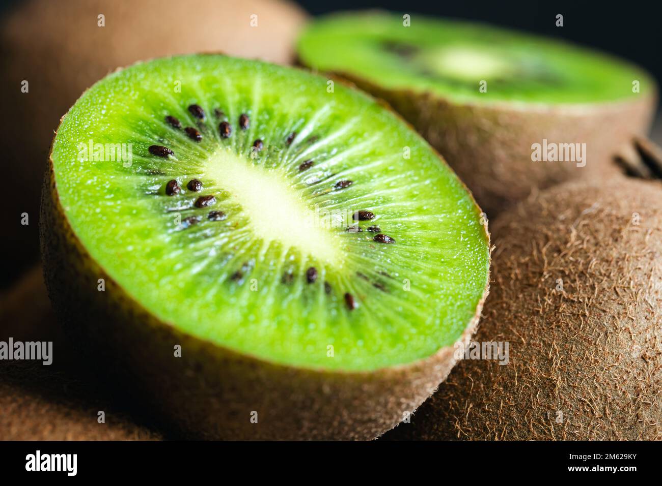 Ripe fruits of kiwi cut and whole, close -up Stock Photo - Alamy