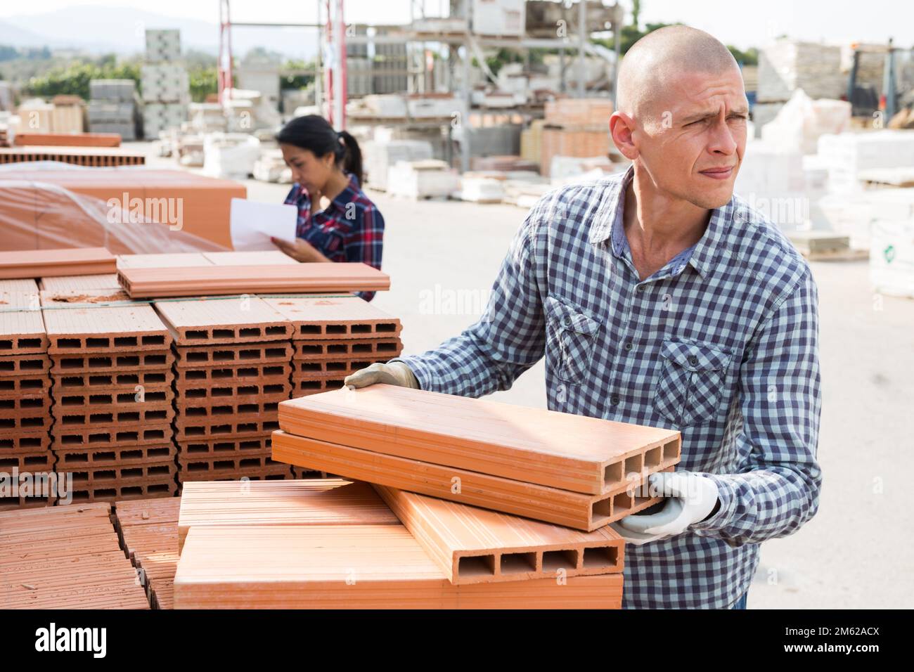 Worker stacking bricks in warehouse of materials Stock Photo Alamy