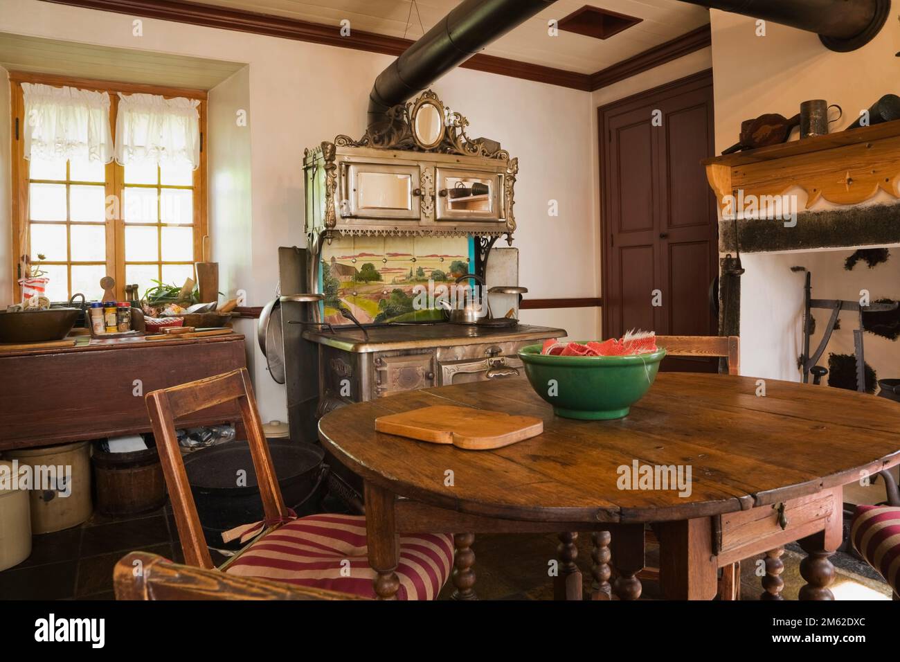 Antique cast iron Chapleau stove and wooden dining table in kitchen
