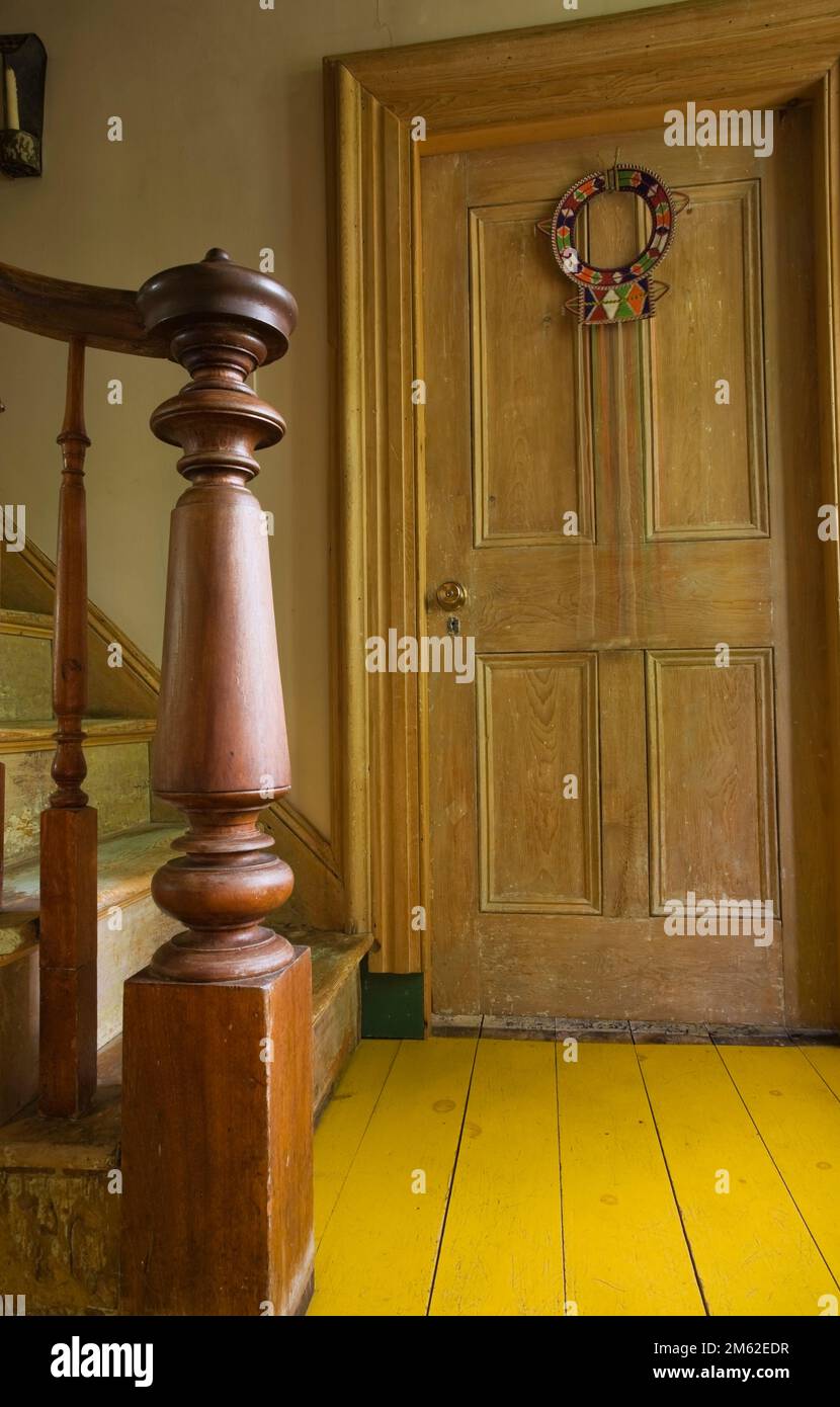 Close-up of turned wooden newel post and steps of main staircase inside old 1838 Canadiana fieldstone home. Stock Photo