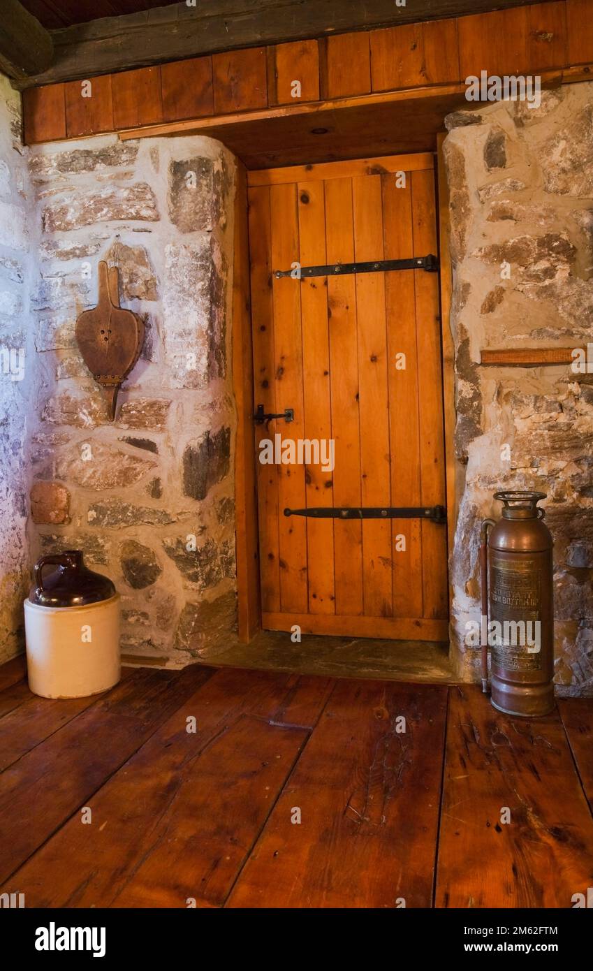 Medieval style wooden bathroom door and wide floorboards inside old circa 1850 cottage style fieldstone home. Stock Photo