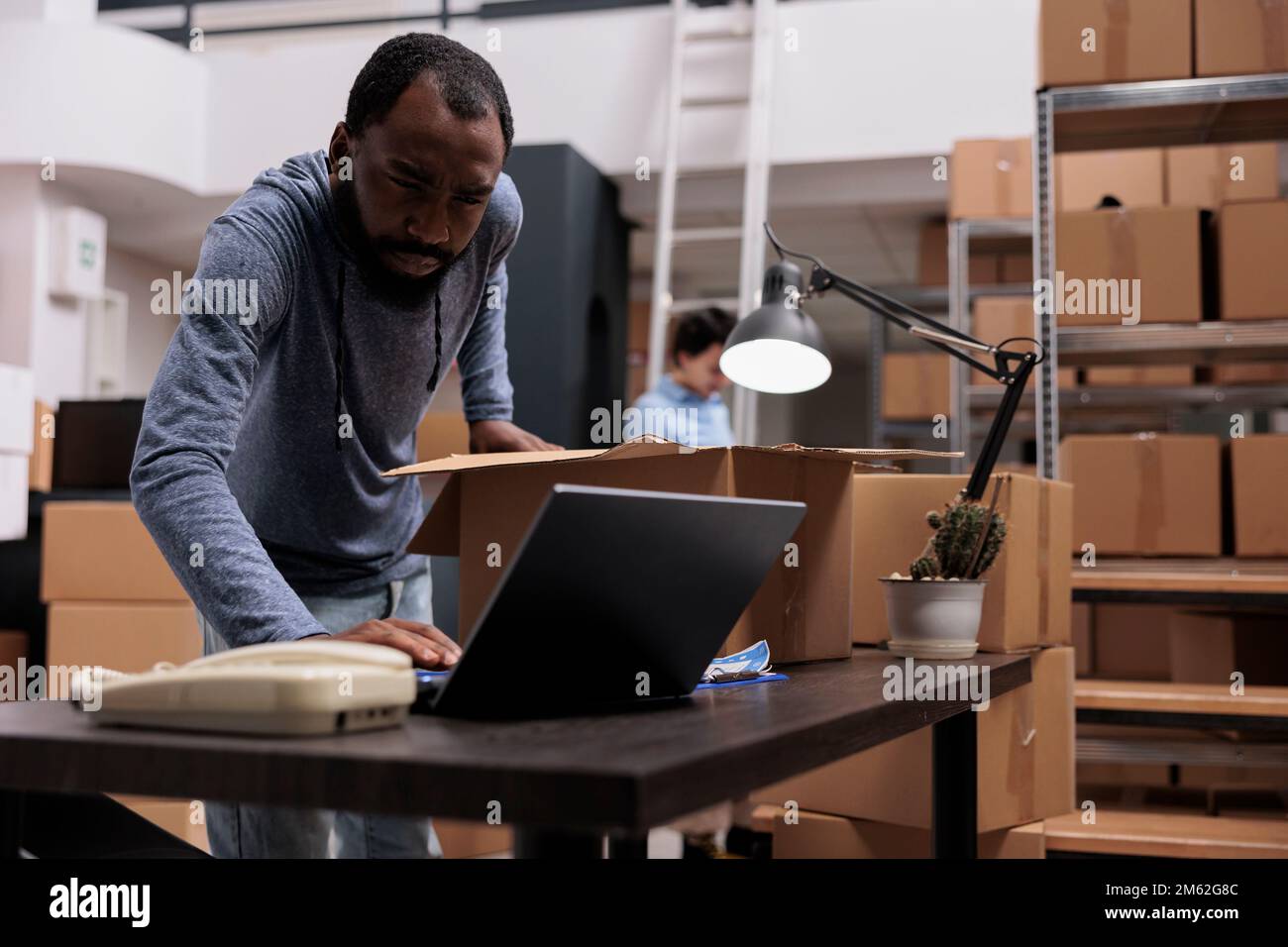African american employee checking stock cargo on laptop computer while ...