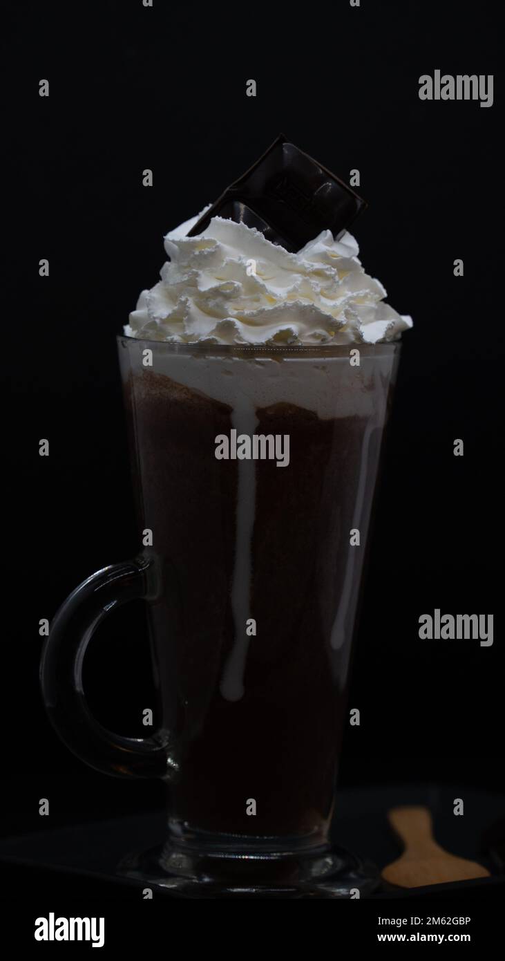 cup of coffee with whipped cream and chocolate on black background Stock Photo