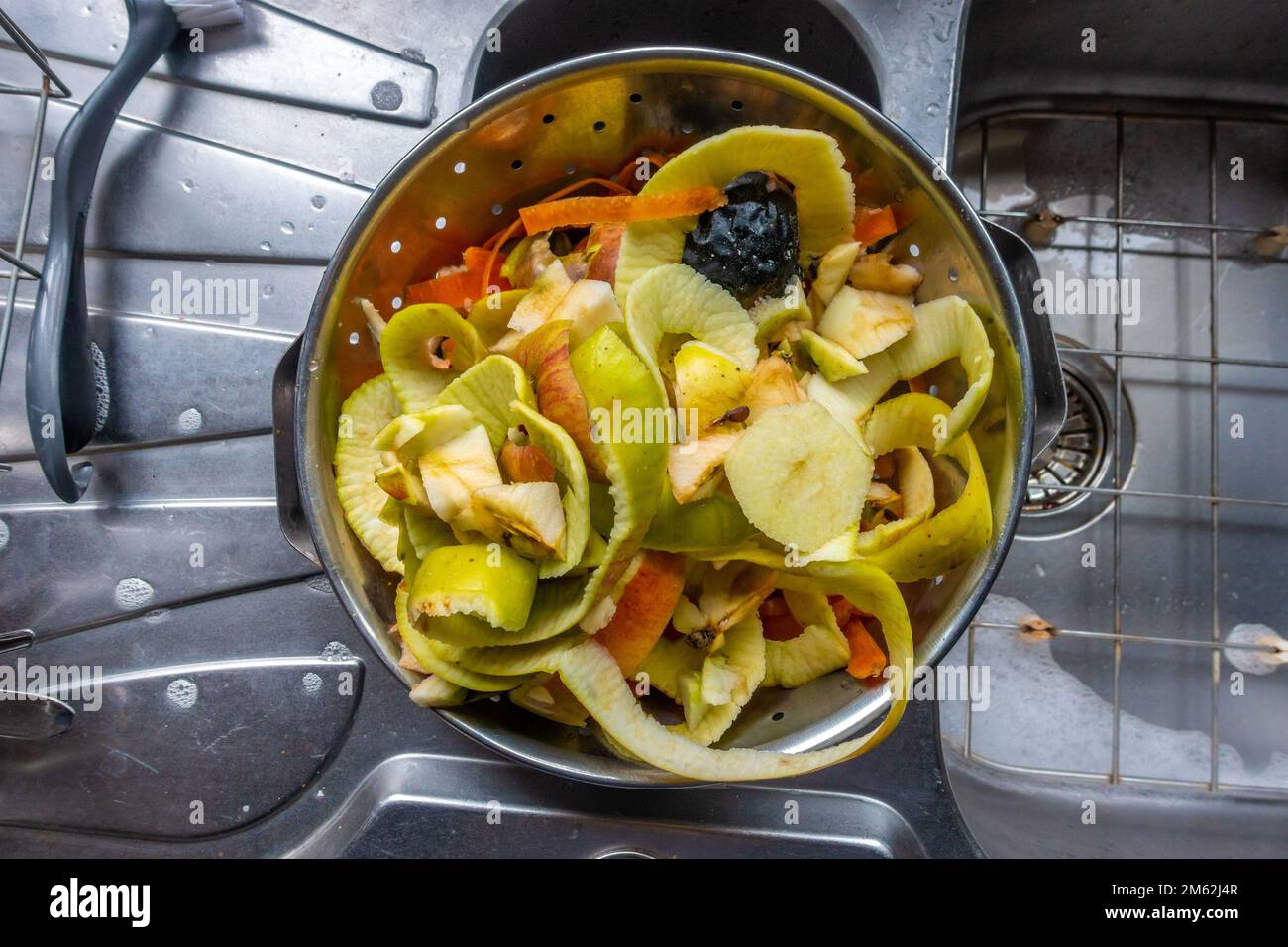 Fruit and vegetable peelings in a metal colander in a residential
