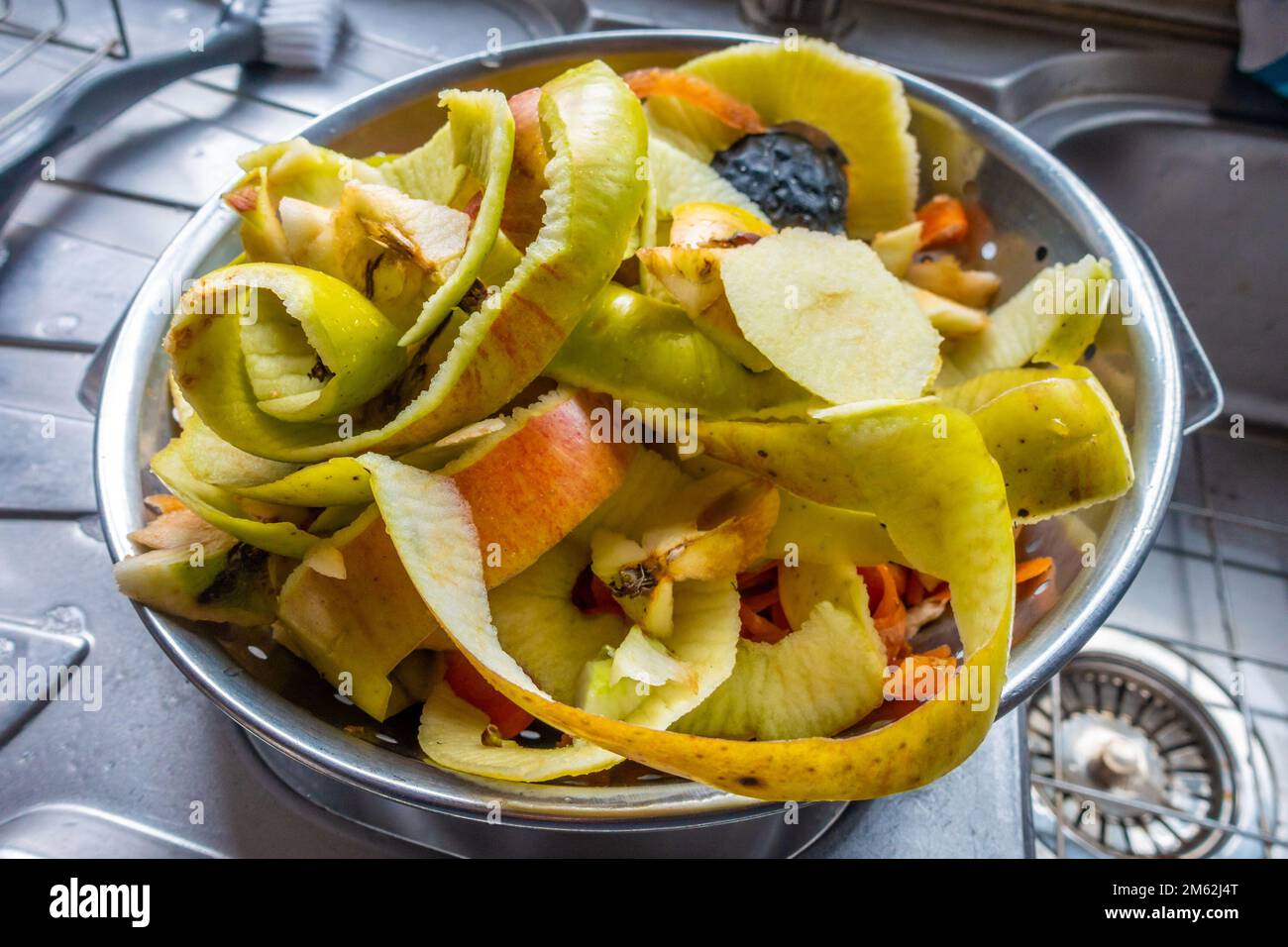 Fruit and vegetable peelings in a metal colander in a residential