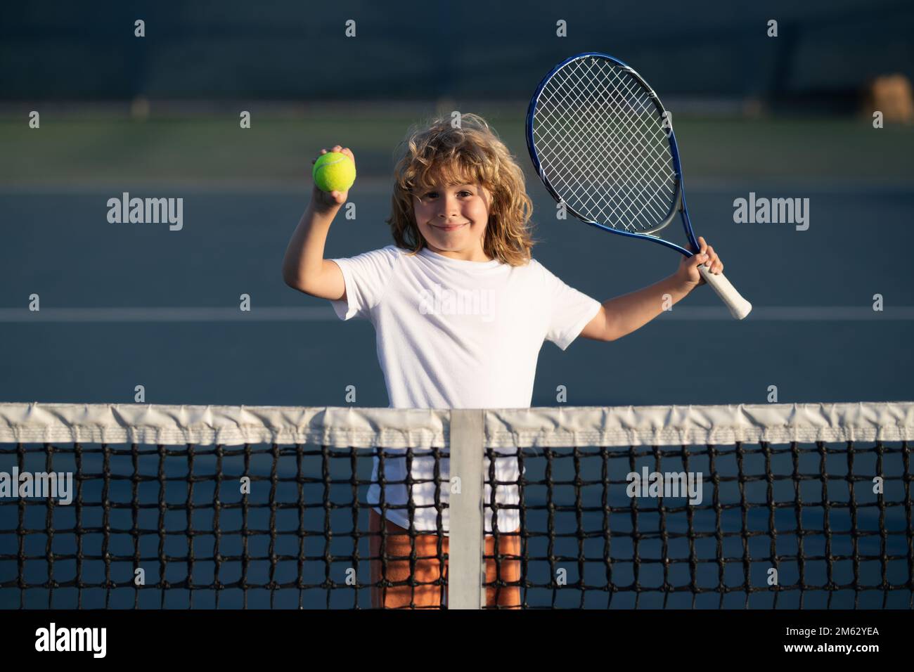 Child playing tennis on outdoor court. Kid with tennis racket and ...