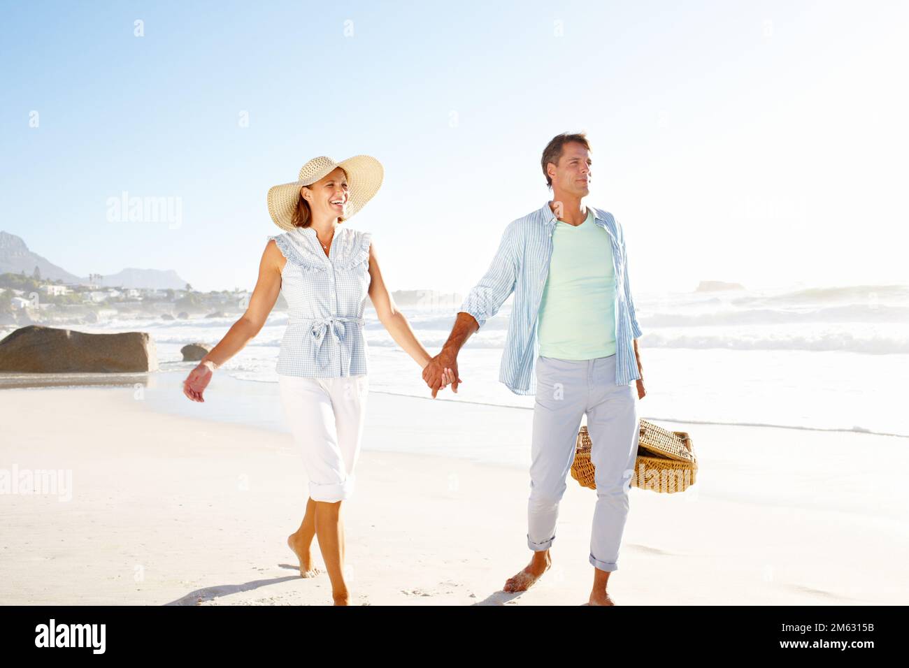 Hand in hand along the beach. A blissful couple enjoying a beautiful ...