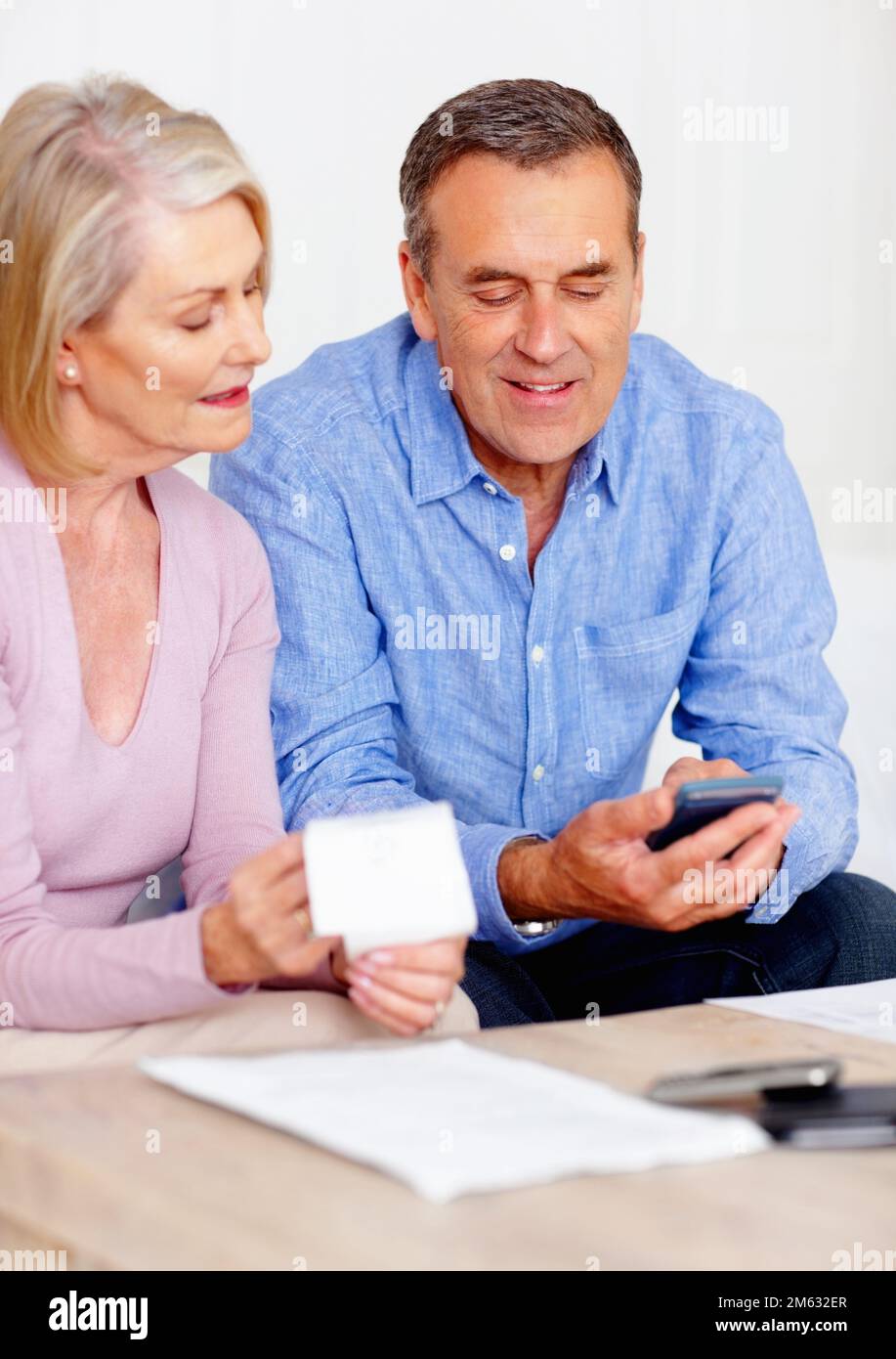 Couple calculating their expenses with the help of calculator. Portrait