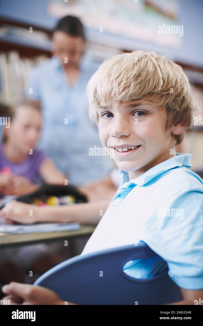Im really enjoying school. An excited young boy sitting in the library