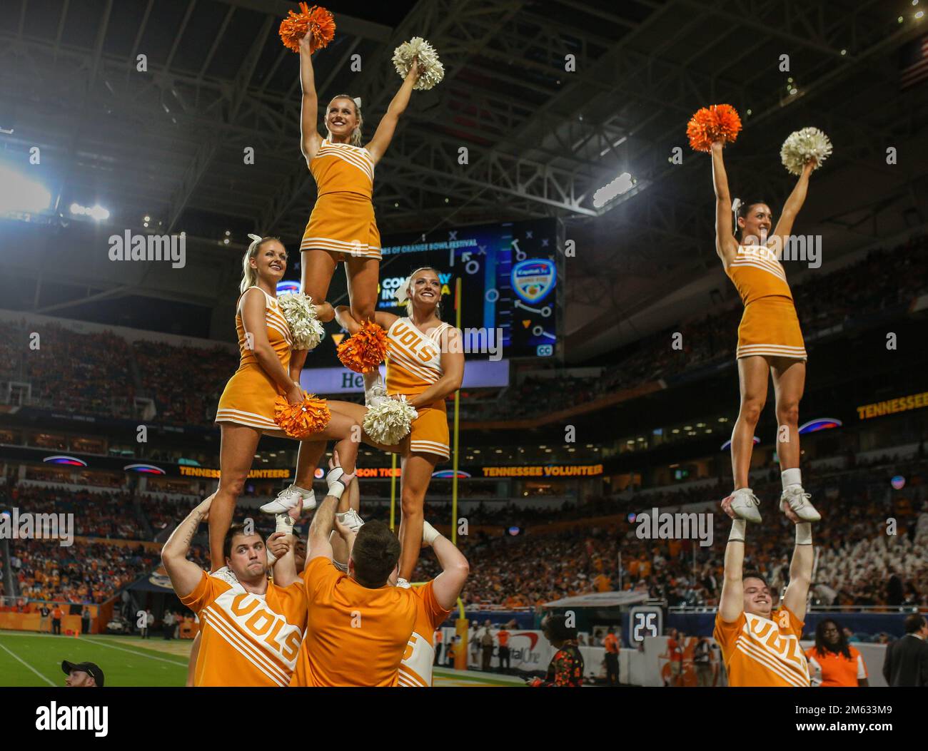Miami Gardens, FL, USA. 30th Dec, 2022. The Tennessee cheerleaders perform partners stunts on the sidelines during the 2022 Capital One Orange Bowl football game between the Clemson Tigers and Tennessee Volunteers at Hard Rock Stadium in Miami Gardens, FL. Kyle Okita/CSM/Alamy Live News Stock Photo