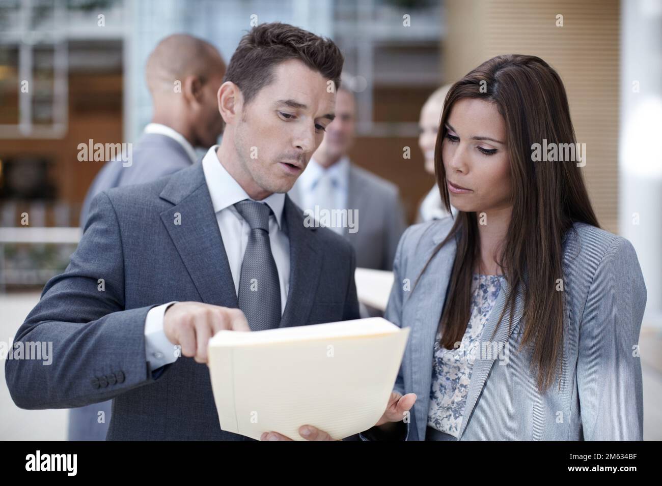This cant be right. Two coworkers looking over paperwork together while looking serious. Stock Photo